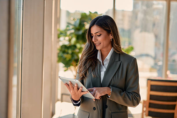 istock Young businesswoman using digital tablet near window in modern office 2220840897