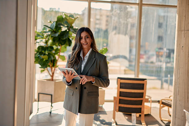 istock Businesswoman using digital tablet in modern office lobby 2220840903