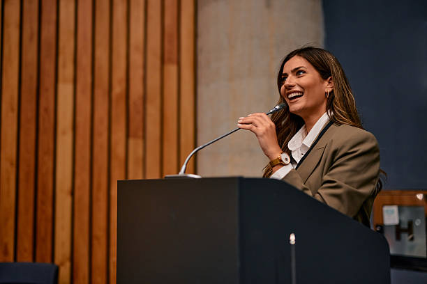 Young businesswoman laughing while speaking at a conference