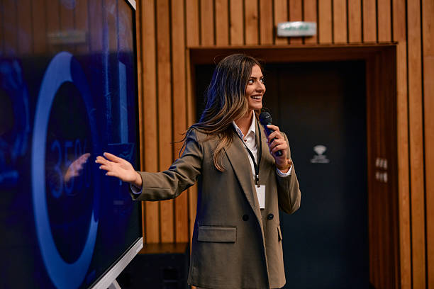 istock Smiling businesswoman presenting company strategy using interactive display and microphone 2220841246