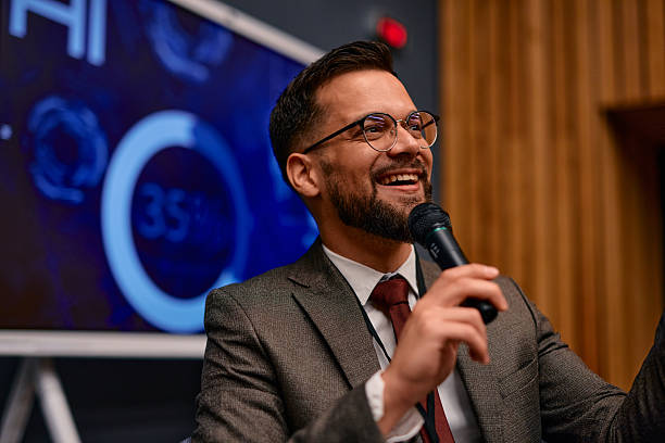 istock Smiling businessman giving a speech during a conference meeting 2220841405