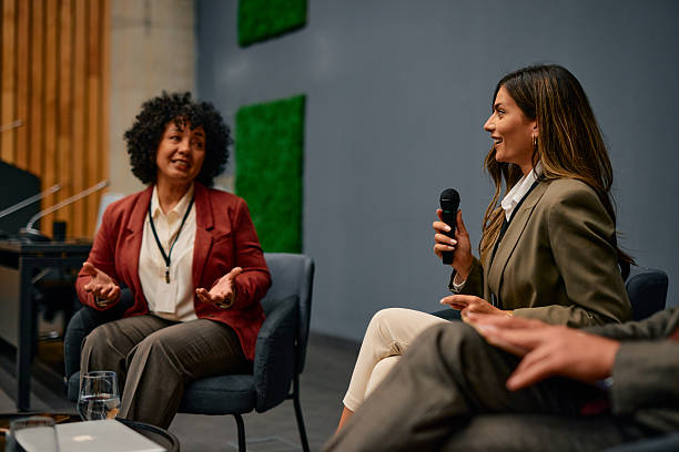 istock Businesswomen speaking at a conference using a microphone 2220841456