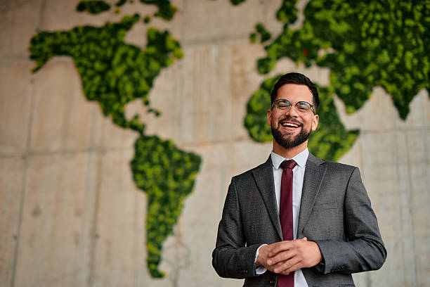 istock Businessman smiling with moss world map on background promoting environmental awareness 2220841512