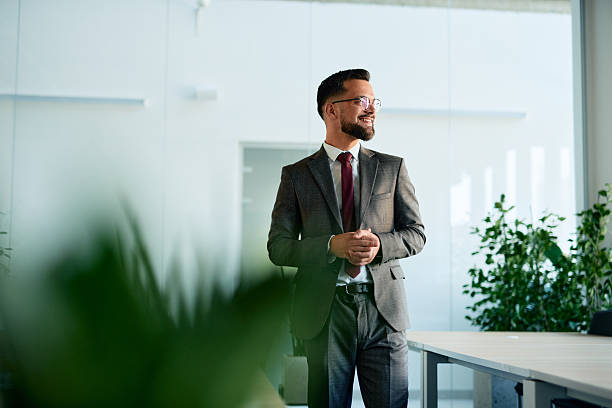 istock Confident businessman looking out the window in modern office 2220841717