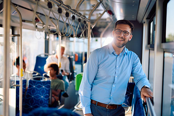 istock Young businessman smiling while standing on a bus during his morning commute 2220842604
