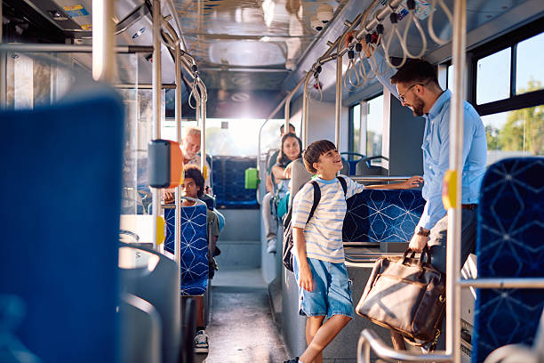 istock Father and son talking while standing on a bus during their commute 2220842669