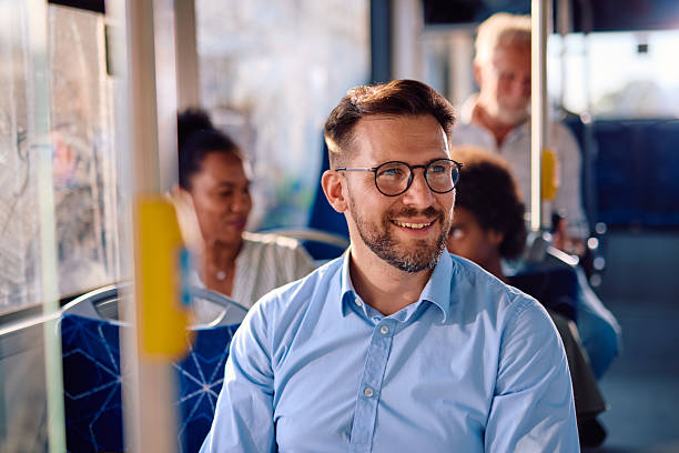 istock Smiling businessman commuting by bus looking away 2220842751