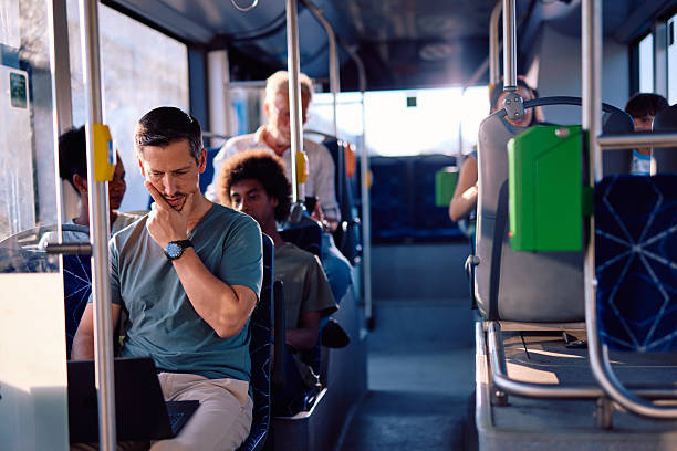 istock Pensive businessman working on laptop while commuting by bus 2220842812