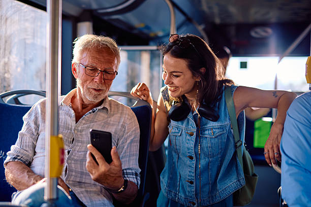 istock Young woman helping senior man using smartphone on the bus 2220842870