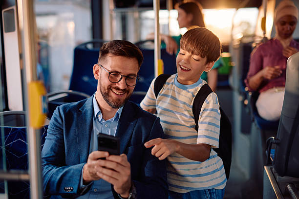 istock Father and son enjoying time together while using a smartphone on the bus 2220843094