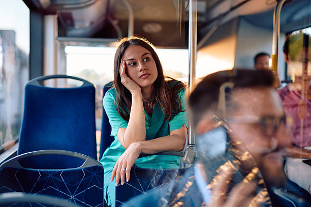 istock Young nurse looking thoughtful while riding on the bus after work 2220843176
