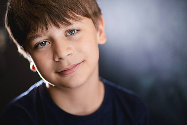 A headshot of a boy with brown hair and blue-colored eyes, looking forward with a slight smile.