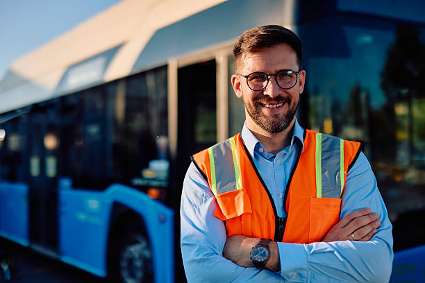 istock Bus driver smiling with crossed arms wearing high-visibility vest 2220843231