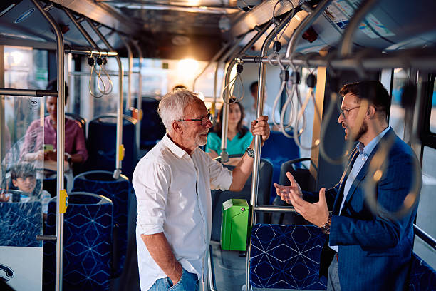 istock Businessman and senior man talking while standing on a moving bus 2220843338