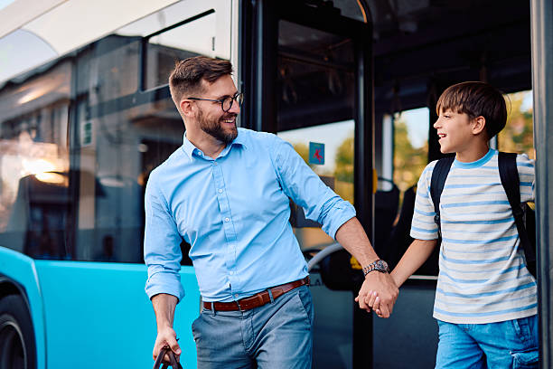 istock Father and son holding hands while exiting the bus after school 2220843417