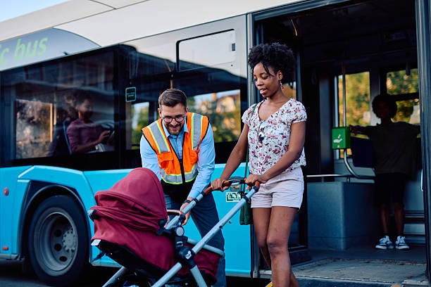 istock Bus driver helping a mother with a stroller getting off the bus 2220843456