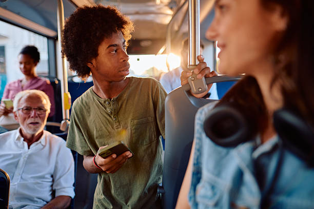istock Young man talking to a woman while standing on a bus 2220843562