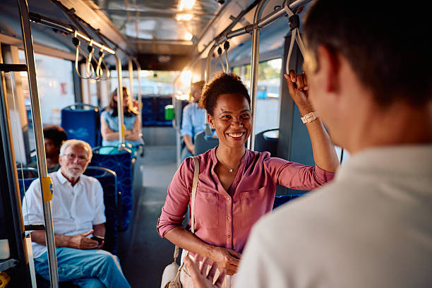 istock Young black woman talking with a friend while standing on a bus 2220843578