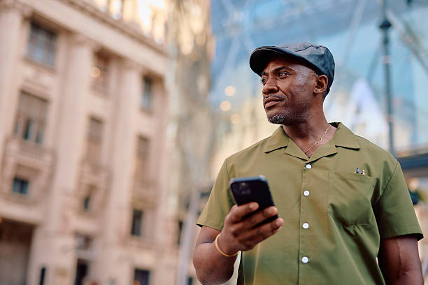 istock Stylish mature man using smartphone in urban setting, looking away thoughtfully 2220843901