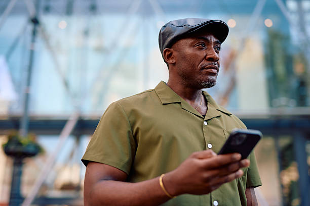 istock Stylish mature man using smartphone in urban setting, looking away 2220843903