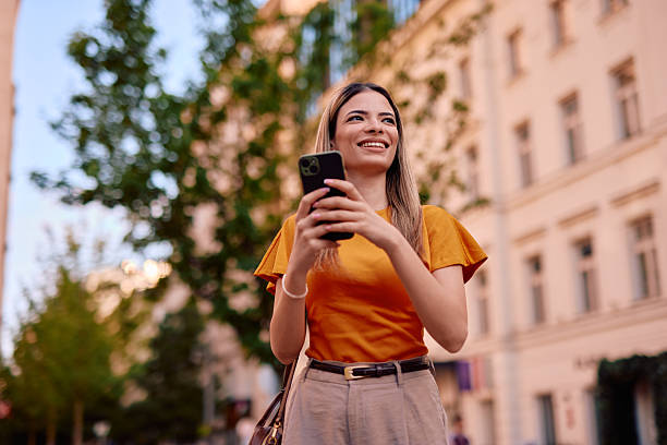 istock Young woman using smartphone and walking in the city 2220844155