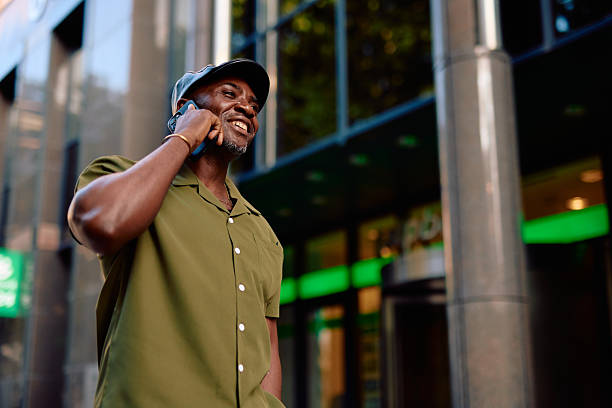 istock Stylish man smiling while talking on smartphone in urban setting 2220844251
