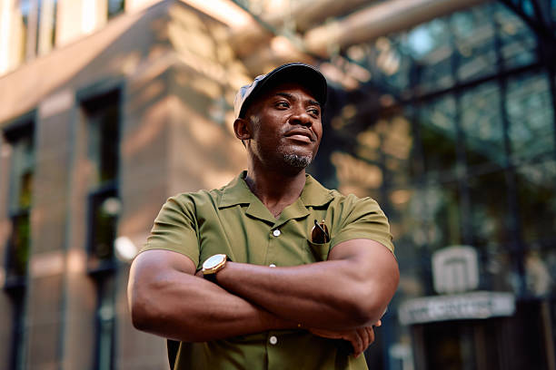 Confident businessman standing with arms crossed in urban setting