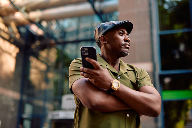 istock Stylish entrepreneur using smartphone and looking away in urban setting 2220844278