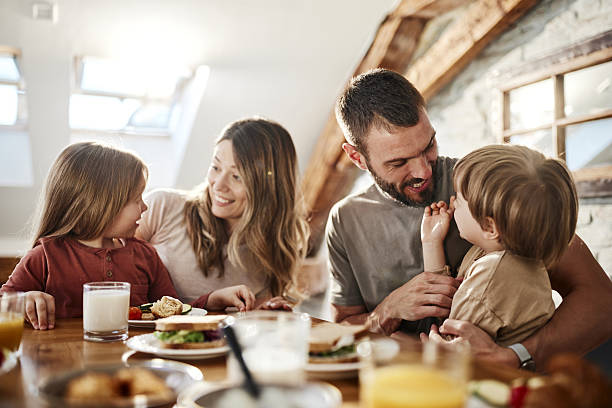 istock Happy parents enjoying with their kids during breakfast at dining table. 2220845853