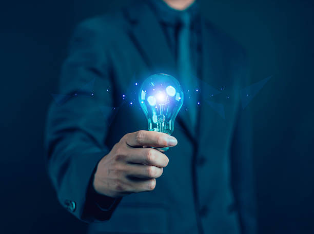 istock Innovation concept and inspiration. Businessman holding creative light bulb with question mark icon. Industry and marketing development network. Strategic planning. 2220846872