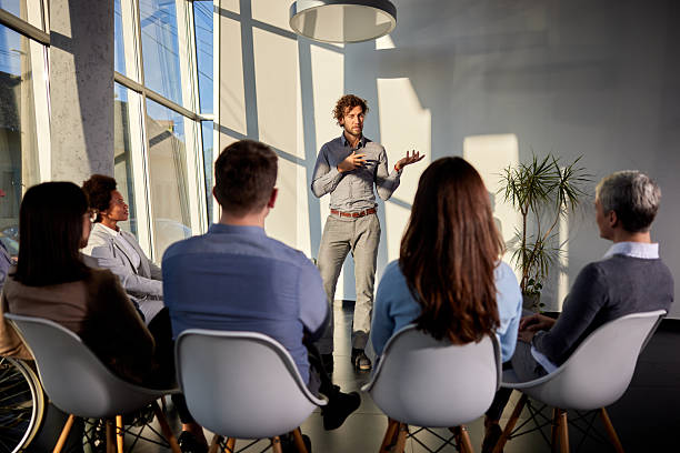 istock Male coach talking on a group therapy in the office. 2220847115