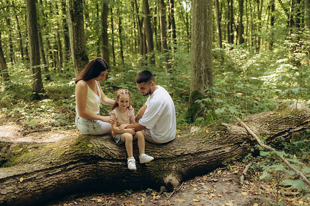 istock Family Bonding Moment on a Forest Log in Natural Greenery 2220847174