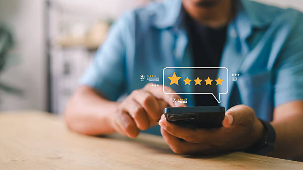 istock Customer using smartphone to give 5-star rating and feedback on digital interface. Concept of online review, user experience, satisfaction, mobile survey, and feedback system. 2220856247