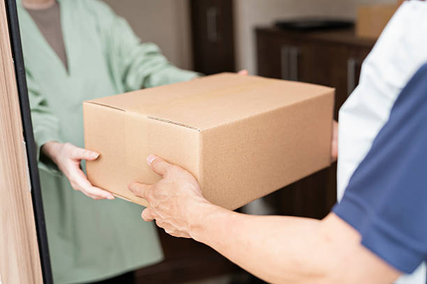 istock 40-something delivery person handing over packages 2220861383
