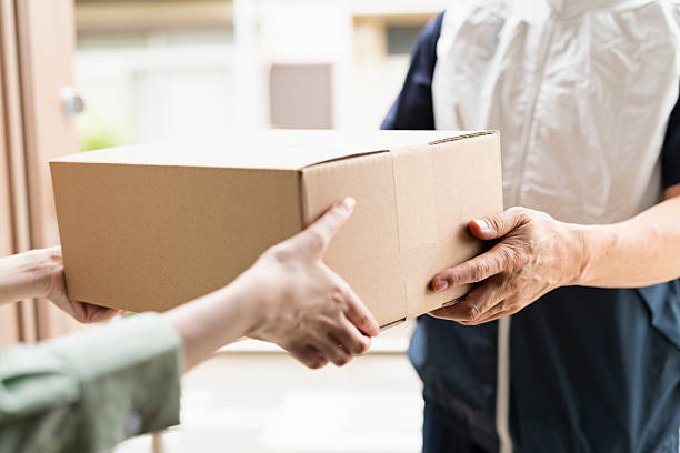 istock 40-something delivery person handing over packages 2220863542