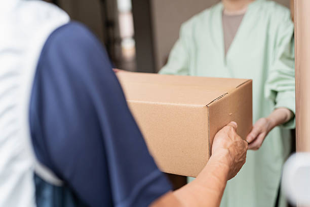 istock 40-something delivery person handing over packages 2220863562