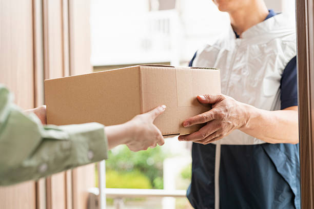 istock 40-something delivery person handing over packages 2220863809