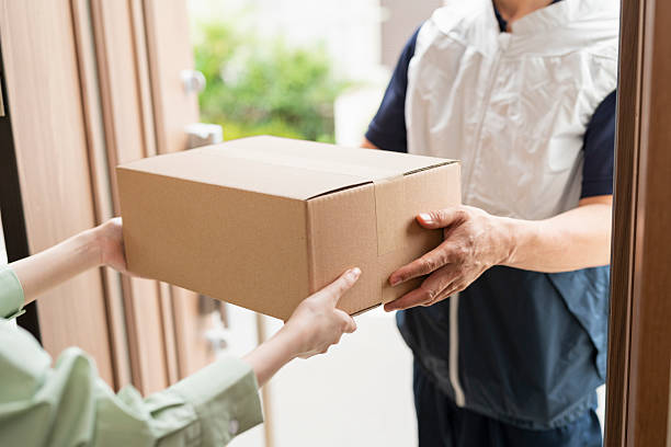 istock 40-something delivery person handing over packages 2220864494