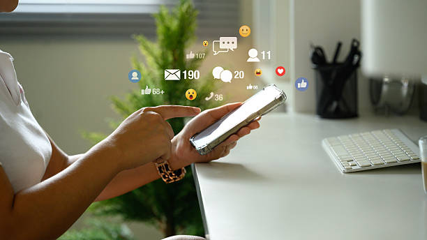istock Hand interacting with phone, surrounded by floating social media icons and notifications 2220865067