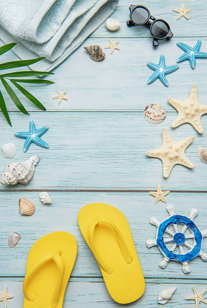Summer essentials creating a frame on a light blue wooden background, ideal for travel and vacation themes