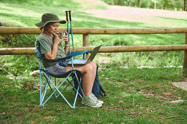istock Woman Working Remotely Outdoors with Laptop in Nature 2220865265