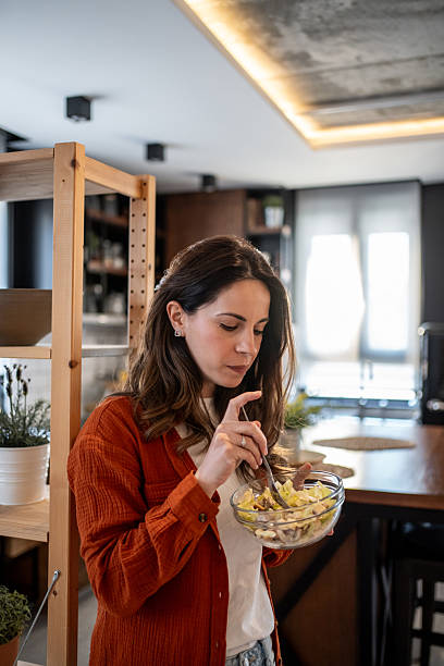 istock Brunette woman enjoying a fresh salad in her modern kitchen 2220865682