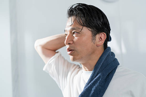 istock A man in his 40s drying his hair after taking a bath 2220867387