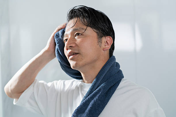 istock A man in his 40s drying his hair after taking a bath 2220867660