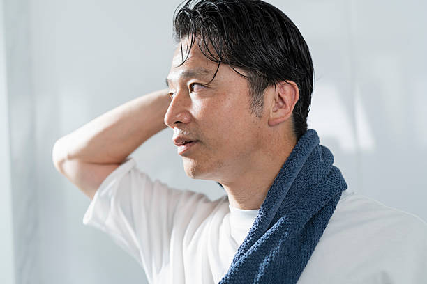 istock A man in his 40s drying his hair after taking a bath 2220867731