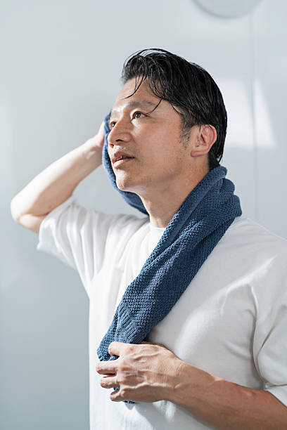 istock A man in his 40s drying his hair after taking a bath 2220867780