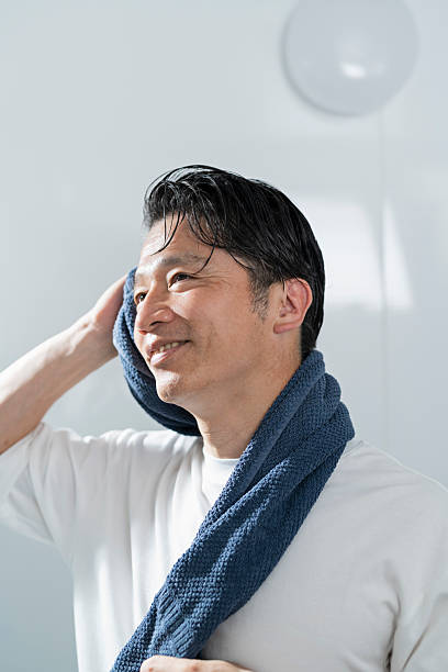 istock A man in his 40s drying his hair after taking a bath 2220867937
