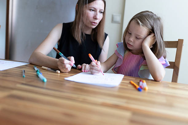 istock Mother helping daughter with homework, learning together at home 2220869548