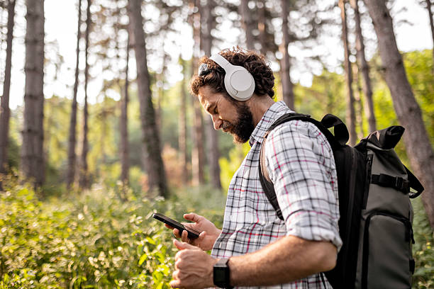 istock Adventurer Hiking with Music and Backpack Using Phone 2220870774