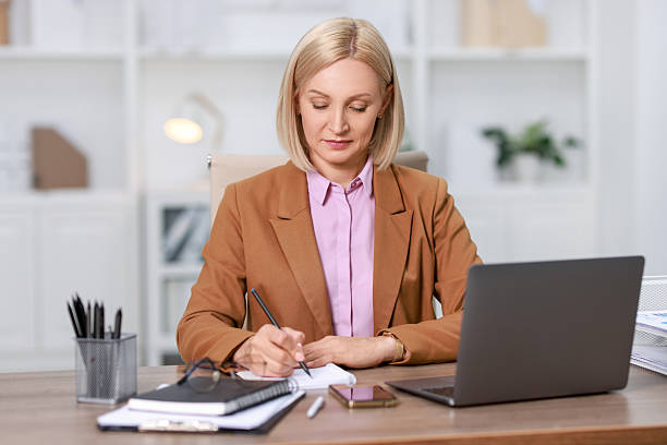 istock Middle aged woman working at table in office 2220871385